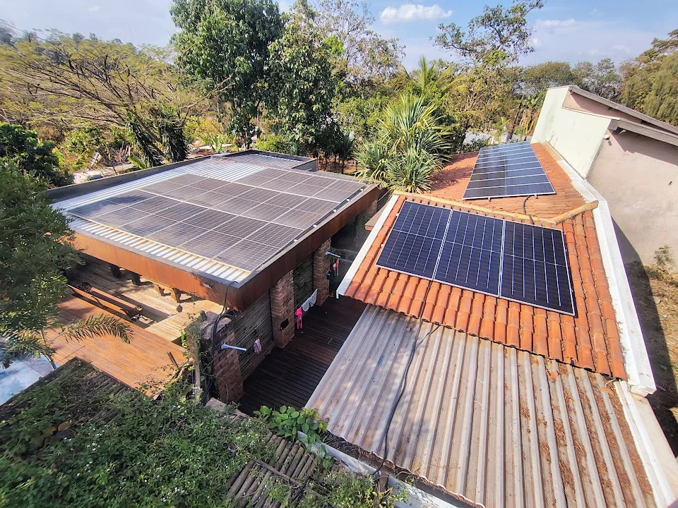 Vista ampla de painéis solares distribuídos em diferentes telhados.